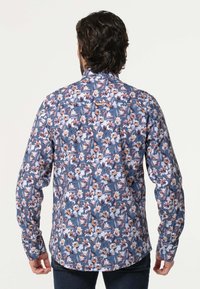 Langsleeve shirt met een blauwe bloempatroon en witte en oranje accenten, gemaakt van lichtgewicht stof, met een afgeronde zoom en knoopsluiting.