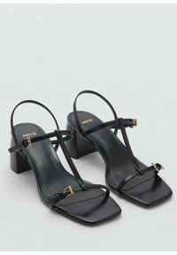 Sandali con tacchi in pelle nera, punta quadrata, cinturini sottili e fibbie in tono oro. Presentano un robusto tacco a blocco per supporto.