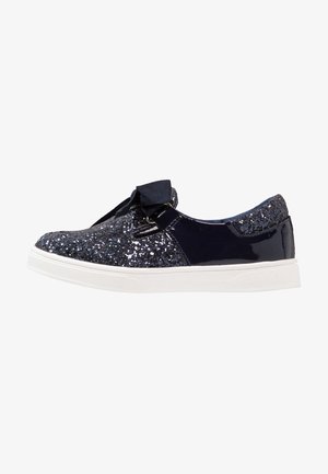 Granatowy błyszczący sneaker z białą podeszwą i zapięciem na satynową tasiemkę, widok z boku na białym tle.