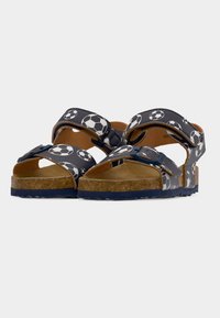 Μπλε σανδάλια με σχέδιο ποδοσφαιρικής μπάλας, ρυθμιζόμενα λουράκια, σόλα που μοιάζει με φελλό, ανοιχτή μύτη και υφασμένο ελαστικό πέλμα για καλύτερη πρόσφυση.