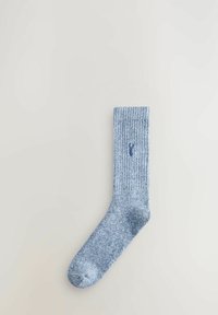 Knitted blue sock with a ribbed cuff, featuring a small logo. Fabric has a textured appearance with a blended yarn design.