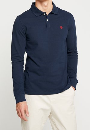 Marineblauwe langwerpige poloshirt van katoen, met een kraag en een klein rood logo op de borst. Glad textuur met een klassieke pasvorm.