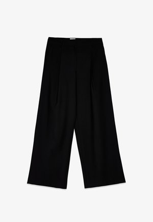 Mustad kõrge vöökoht ja laiad püksid, millel on voldid ja sile tekstuur. Disain on minimalistlik, ilma nähtava riistvarata.