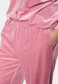 Samta mājas apģērba komplekts maigā rozā krāsā ar elastīgu jostasvietu, kabatām un gludu tekstūru ar smalku spīdumu un kvalitatīvu izšuvumu.