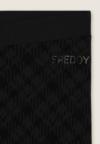 Leggings neri con un motivo testurizzato caratterizzato da forme astratte e un'ampia vita. Il marchio "FREDDY" è decorato con strass.
