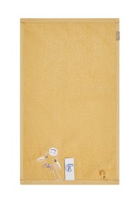 Yellow towel with a textured surface, featuring an embroidered design of a character at the bottom left and a tag on the right.