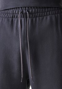 Dark gray sweatpants feature an elastic waistband with a drawstring, smooth texture, and a relaxed fit. No visible pockets or patterns.