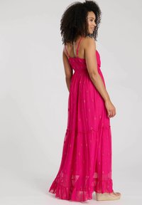 Maxikleid aus hellpinkem Chiffon mit einem schichtartigen Rock, dünnen Trägern und durchgehendem Stickmuster. Mit einem Volant-Saum.