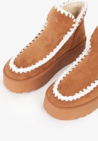Stivali platform in suede marrone con trim peloso bianco e suole in gomma spessa, dotati di un caldo rivestimento interno in pile.