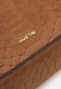Brun tekstureret kunstlædertaske med et reptilmønster. Har guld "PARFOIS" branding og mørkeblå kanter. Glat overflade, rektangulær form.