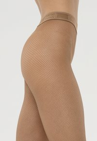 Collant a rete color carne con una superficie texture e una vita larga con logo. Il design presenta un motivo a griglia e una finitura trasparente.