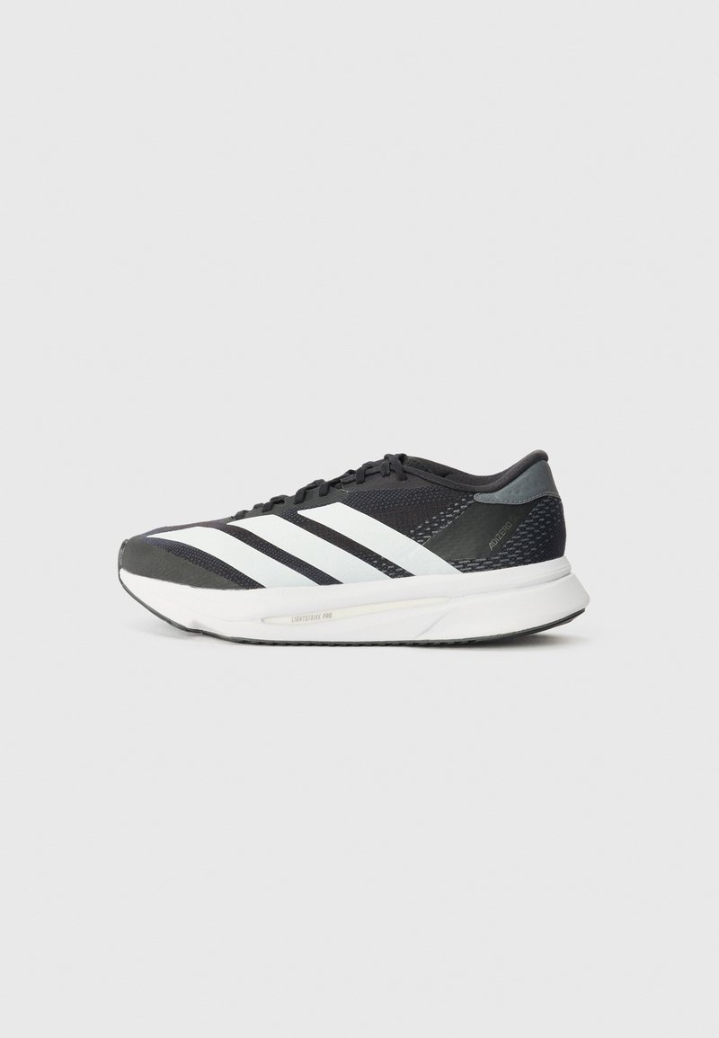 Chaussure de sport noire avec des rayures blanches, tige en maille, semelle rembourrée et un design épuré. Accents gris au niveau du talon et de la languette.