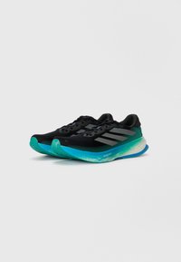 Scarpe da allenamento nere con una tomaia in mesh traspirante, caratterizzate da una suola turchese e strisce grigie. Design leggero, texturizzato per migliorare la presa.