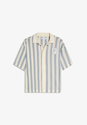 Košulja s kratkim rukavima na kopčanje, s okomitim kremastim i svijetloplavim prugama, kamp ovratnikom i emblemom "P" na lijevoj strani prsnog dijela.