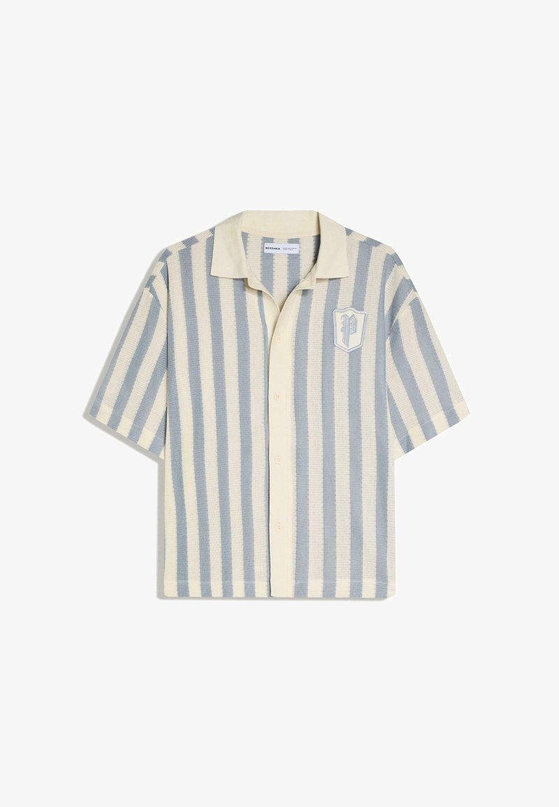 Kortærmet skjorte med knapper, lodrette striber i creme og lyseblå, camp-krave og et "P" emblem på venstre bryst.