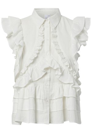 Blouse blanche sans manches avec bordure à volants, fermeture boutonnée à l'avant et détails en tissu superposés à étages.