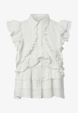 Blouse blanche sans manches avec bordure à volants, fermeture boutonnée à l'avant et détails en tissu superposés à étages.