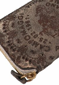 Borsa in cuoio marrone con motivi floreali scolpiti, una cerniera dorata e una texture leggermente invecchiata. L'etichetta include "Campomaggi" e la data.