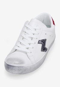 White leather sneaker with grey rubber sole, featuring black glitter accent on the side and a red heel tab. Flat laces and rounded toe design.