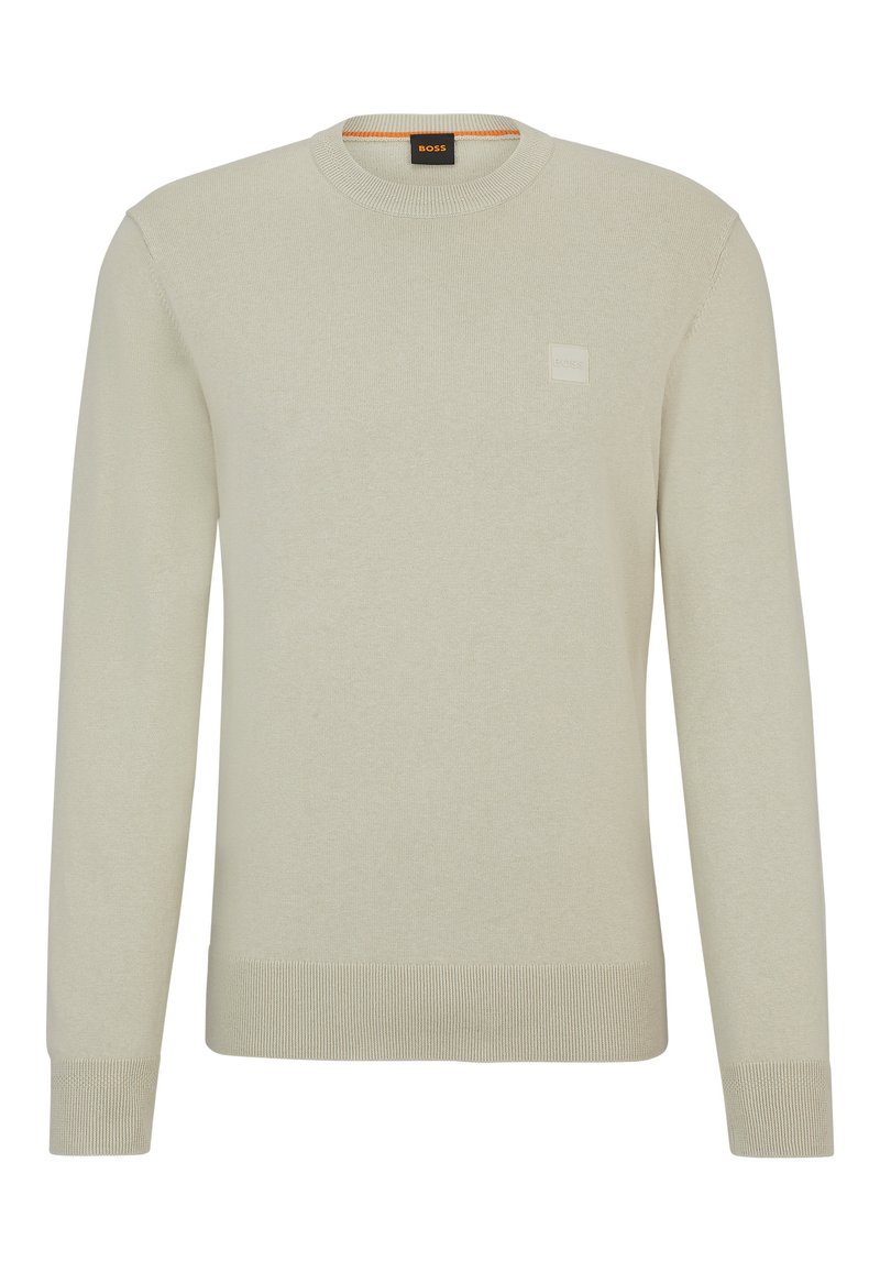 Lichtbeige gebreide trui met een ronde hals, lange mouwen en een textuurafwerking. Beschikt over een klein logolabel op de borst.