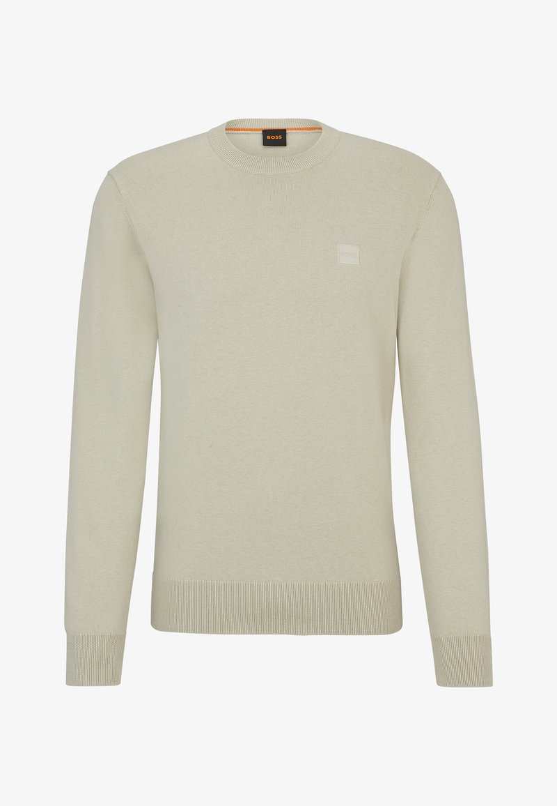 Suéter de punto beige claro con cuello redondo, mangas largas y un acabado texturizado. Presenta una pequeña etiqueta de logo en el pecho.