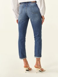 Jeans de mezclilla azul oscuro con ajuste slim, puños enrollados y bolsillos traseros. Presentan un ligero desgastado y una textura suave.