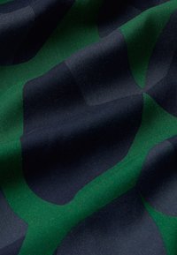 Textil con un patrón ondulado en tonos azul marino oscuro y verde, con una textura suave y un brillo sutil, que resalta la caída y los contornos de la tela.