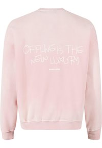 Felpa rosa in morbido cotone con collo rotondo, polsini e fondo a coste. Testo sul retro: "ESSERE DISCONNESSI È IL NUOVO LUSSO."