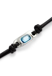 Pulsera de cordón de cuero negro con un engaste rectangular de plata que presenta una gema azul facetada en el centro.