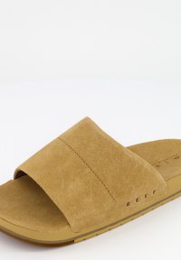 Sandale à glissière en suède tan avec une large sangle, un dessus en cuir doux et une semelle intérieure rembourrée. Comprend une semelle extérieure en caoutchouc avec un détail de marque.