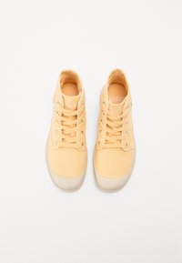 Sneakers din pânză galbenă cu vârf rotund, talpă din cauciuc alb și un design clasic cu șireturi, dotat cu ochiuri metalice. Partea superioară texturată și căptușeala moale.