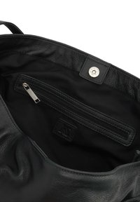 Crna kožna torba meke teksture s unutarnjim zip džepom i kružnim zatvaranjem na dugme. Obložena crnom tkaninom.