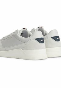 Szare skórzane i zamszowe sneakersy z białymi podeszwami, z granatowym akcentem i detalem logo na pięcie. Klasyczny system sznurowania.