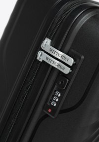 Black hard-shell suitcase featuring a double zipper with "WITTCHEN" engraving, a combination lock, and textured surface.