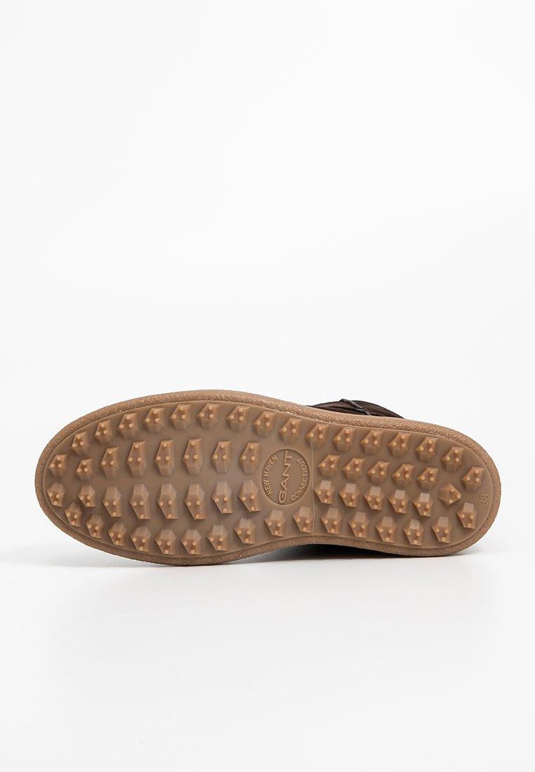 Sohlenprofil mit zahlreichen dreieckigen Stollen für Traktion, mit dem Logo "GANT New Haven Connecticut" und der Größenmarkierung 38 auf einem weißen Hintergrund.