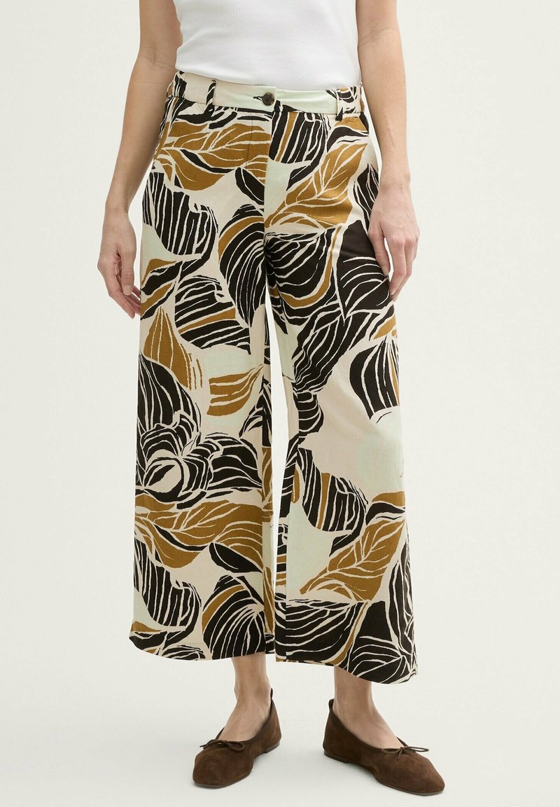 Pantalons évasés à jambes larges en tissu léger, ornés d'un motif de feuilles audacieux en noir, marron et crème. Comprend une fermeture à bouton à l'avant et des poches.