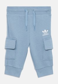 Ljusblå Adidas sweatsbyxor för småbarn med dragsko i midjan, sidofickor, ribbade muddar och vit Adidas-logga på vänster lår.