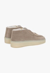 Leren enkelboots in lichtbruin met een zachte, fuzzy voering, met een ronde neus en een dikke, neutraal gekleurde zool.