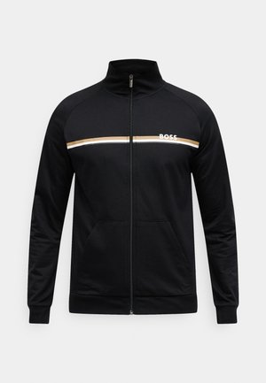 Melnas rāvējslēdzēja jaka no mīksta auduma. Krūšu daļā ir balta un zelta horizontāla svītra ar "BOSS" logotipu, kā arī priekšējās kabatas.