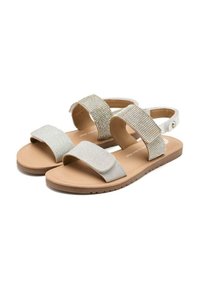 Sandali argentati luccicanti con due cinghie; una è decorata con strass, l'altra è in morbido tessuto. Suola in gomma color sabbia, fascetta alla caviglia regolabile.