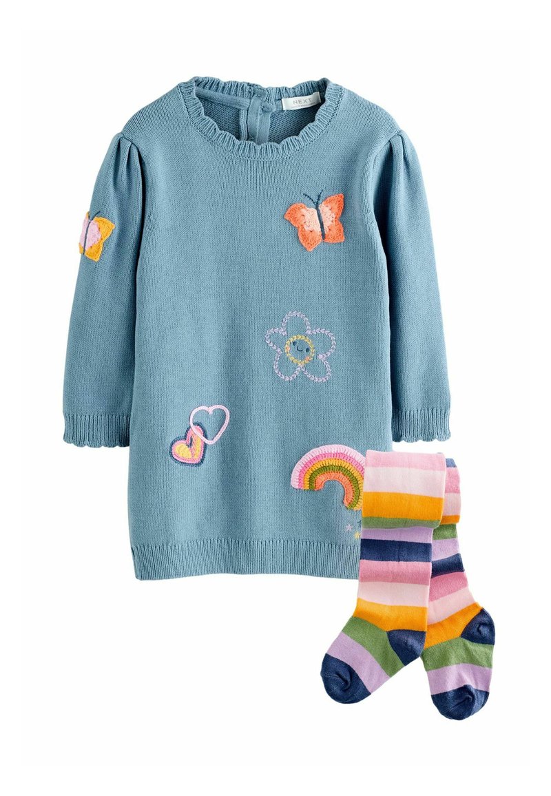 Blauwe gebreide jurk met borduursels van een vlinder en bloemen; gerimpelde kraag. Gestreepte sokken in roze, geel, groen en blauwe kleuren.