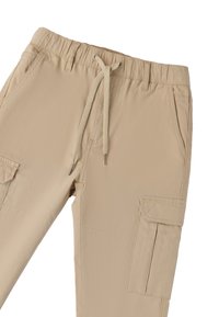 Beige cargobroek van textuurstof met een elastische tailleband, trekkoordsluiting en meerdere zijzakken.