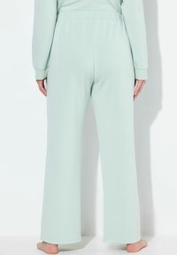 Mintgroene pyjamabroek met een relaxte pasvorm, elastische tailleband en ruime pijpen. Zachte stoftextuur, minimale stiksels en geen zichtbare patronen.