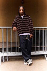 Brun- och cremefärgad fleecepullover med halv dragkedja, kombinerad med lösa jeans och canvas-sneakers. Nycklar fästa med en kedja.