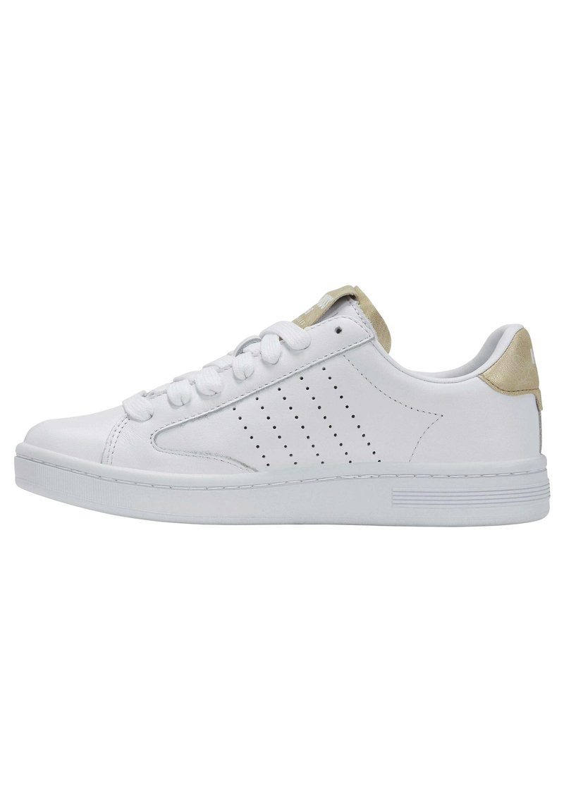 White leather sneaker with perforated side design and light beige accents on the heel. Features a flat rubber sole and padded tongue.