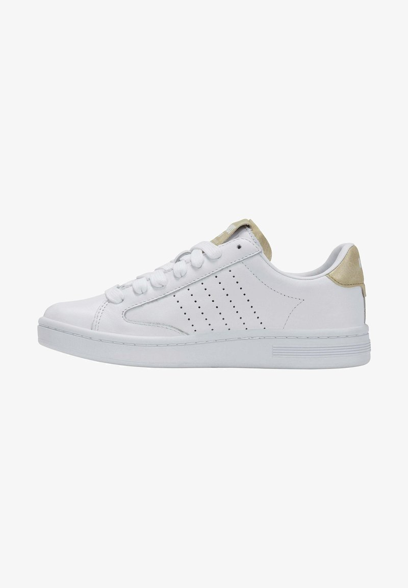 White leather sneaker with perforated side design and light beige accents on the heel. Features a flat rubber sole and padded tongue.