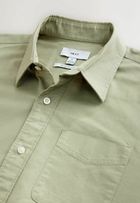 Licht olijfgroene knoopshirt van katoen, met een zak, spitse kraag en een regular fit ontwerp.