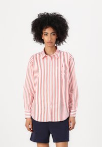 Long-sleeve button-up shirt with red and white vertical stripes. Features a collar and a chest pocket. Fabric appears smooth and lightweight.