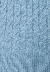 Helles blaues Strickpullover-Gewebe mit einem Kabelstrickmuster und einem gerippten Textur am unteren Ende. Sanfte und flauschige Materialien sind sichtbar.