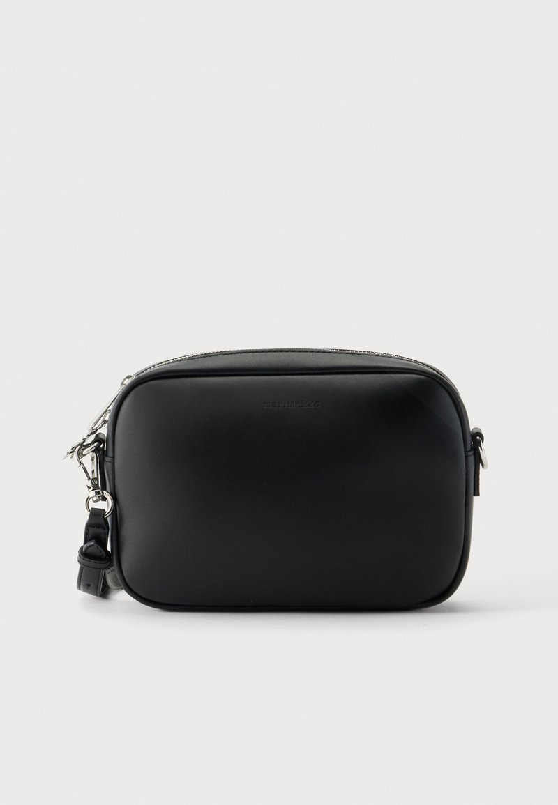 Μικρή ορθογώνια μαύρη τσάντα crossbody με λεία υφή, φερμουάρ στο επάνω μέρος και αποσπώμενο λουράκι με ασημί μεταλλικά μέρη, σε απλό φόντο.